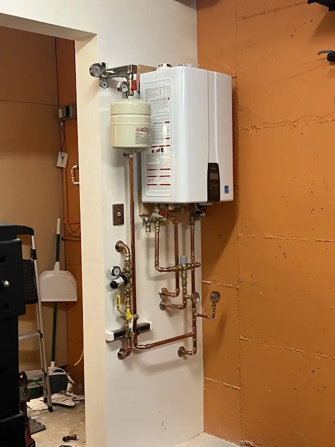 Plumbing technician inspecting water heater connections in Cuyahoga Falls